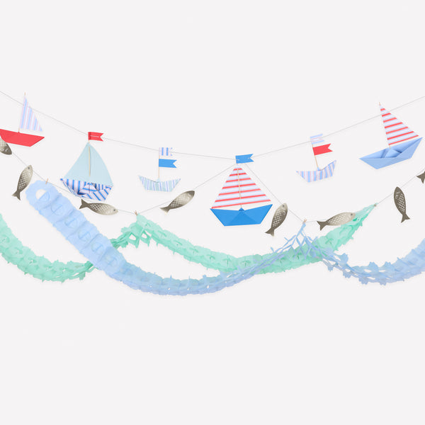 Add a touch of seaside fun to your nautical party with our special paper garland set, featuring striped boats, shiny fish and honeycomb waves. Image1