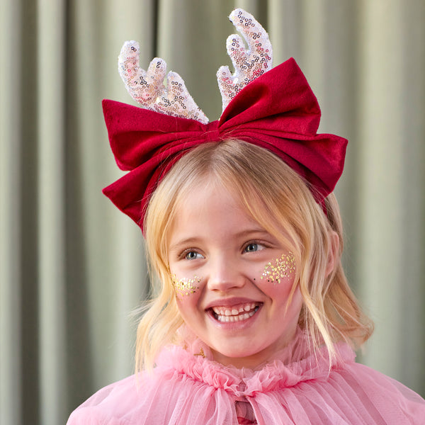 Our reindeer headband is a fabulous accessory to wear to Christmas parties, with silver sequin antlers, and a red velvet bow and headband. Image1