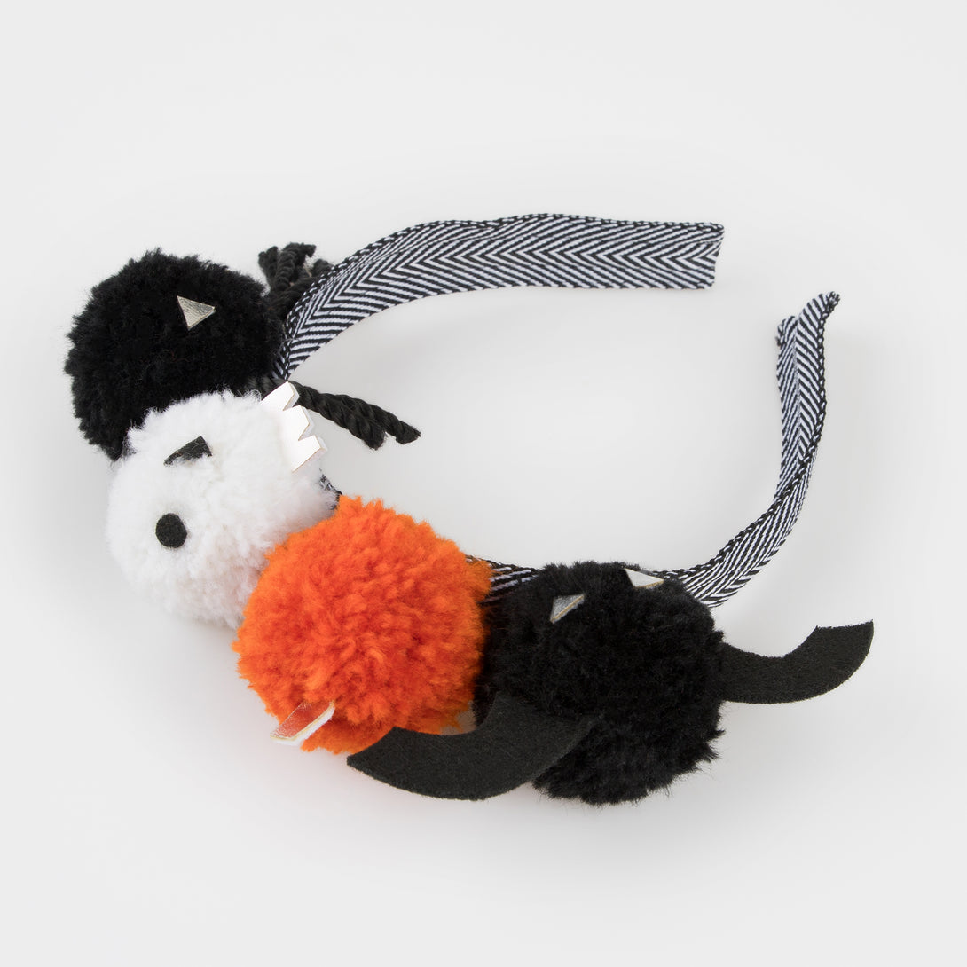 Add our Halloween headband, with fun pom pom details, to your Halloween accessories for a thrilling look.