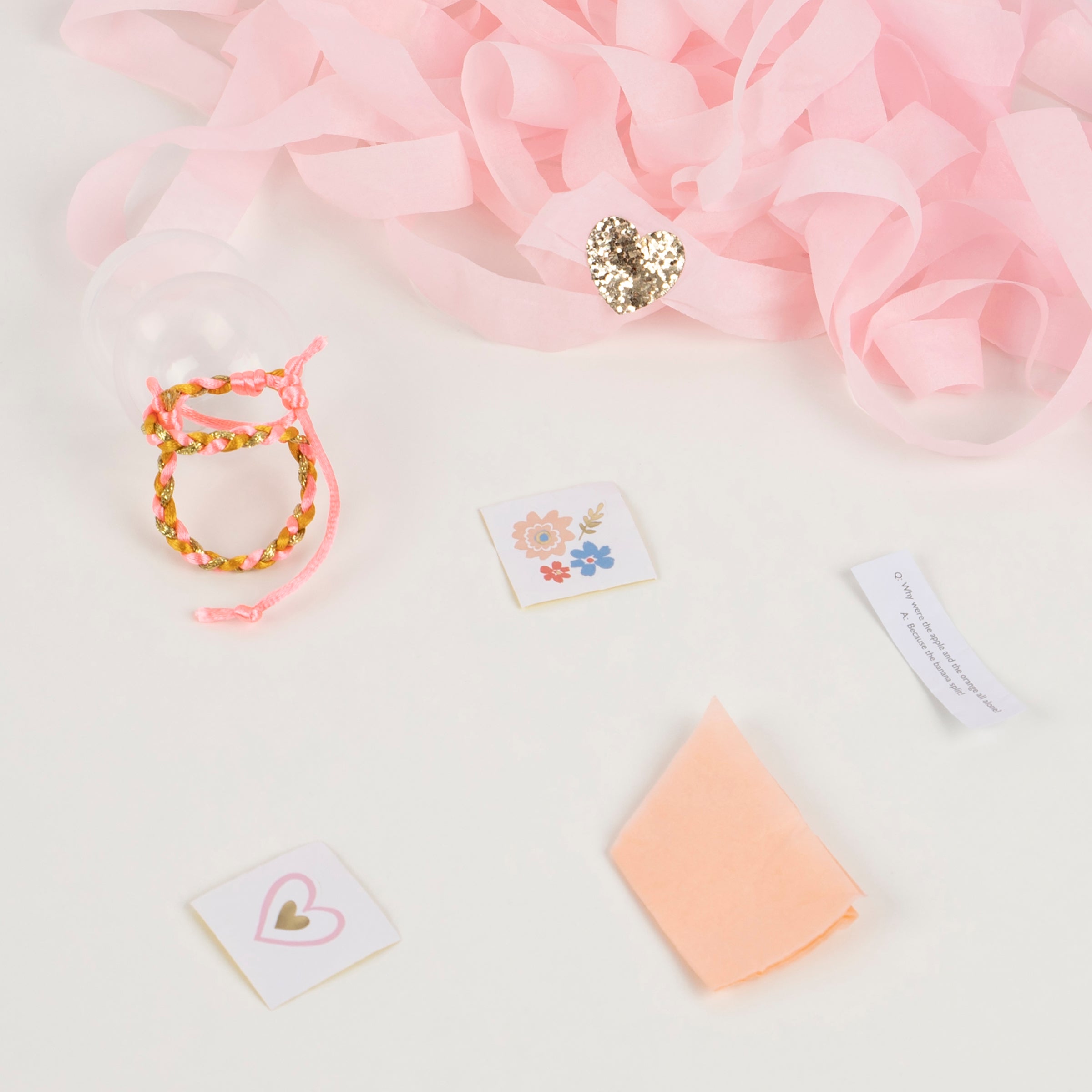 These are crafted with pink tones of crepe paper, and feature friendship bracelets, paper party hats and foil stickers.