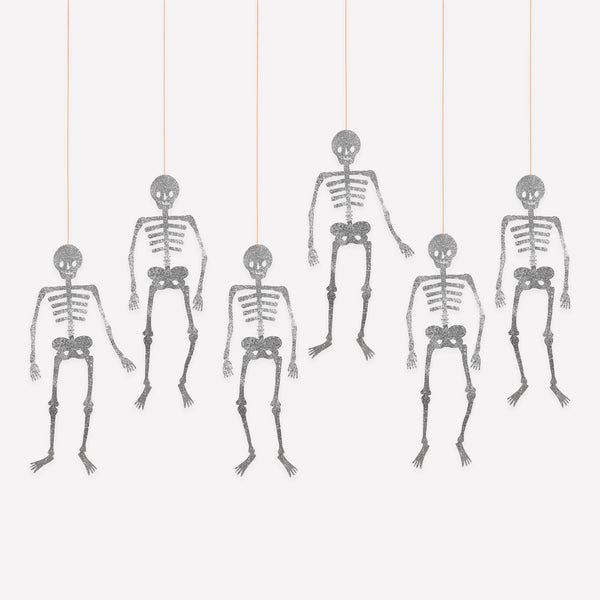 Our pack of six Halloween skeleton decorations, with moveable joints and chunky silver glitter, are perfect to add fun and sparkle to your party. Image1