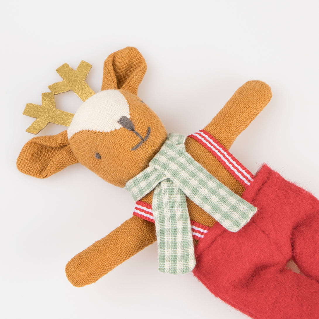 Our Christmas doll set includes a mini fabric reindeer doll in a laminated mini suitcase designed to look like a gingerbread house.