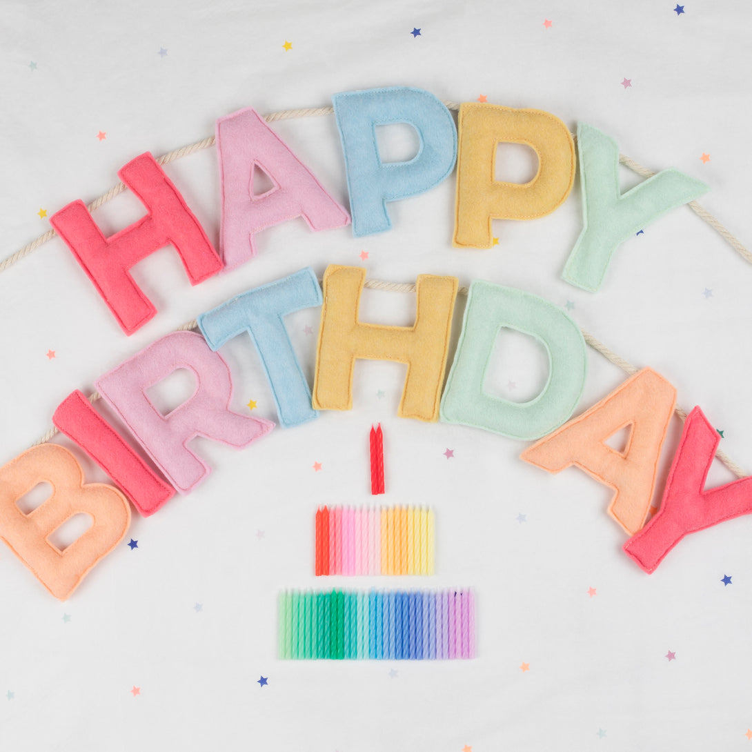 Add a rainbow of colour to your birthday party supplies with a colourful felt garland, paper tablecloth and bright birthday cake candles. 