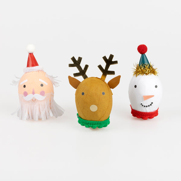 Our surprise balls, in the shape of Santa, a snowman and a reindeer, contain a gold party hat, 2 stickers, a joke and a fun eraser. Image1