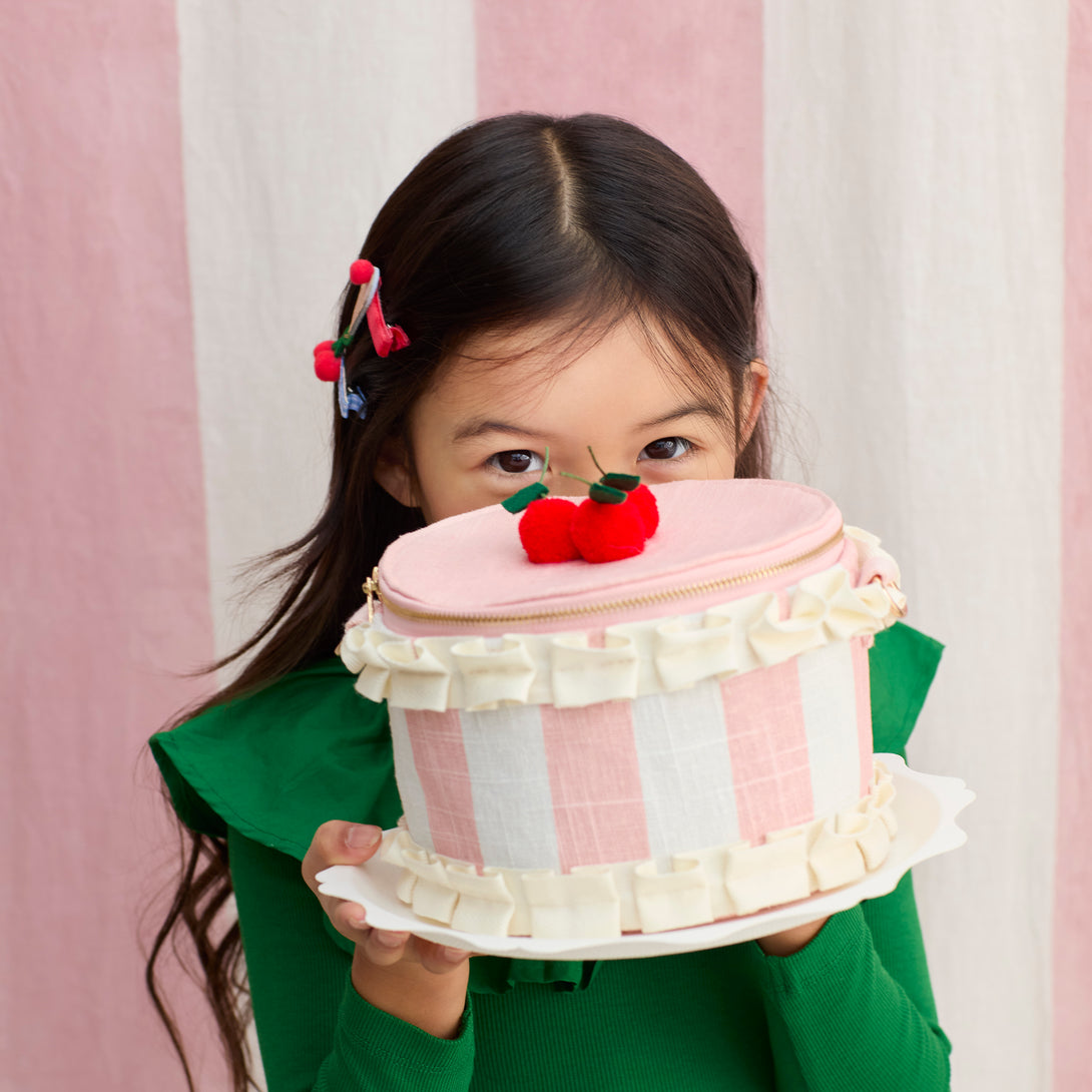 Our pink fabric bag, crafted to look like a cake, features fun pompom cherries, felt leaves, a ruffled ribbon and a long webbing handle.