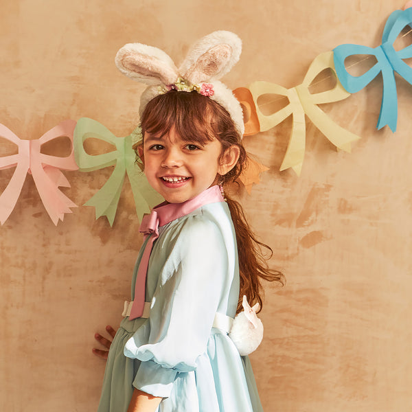 Our Easter costume, a set of bunny ears and tail, is made from plush fabric and presented in a gingham bag.