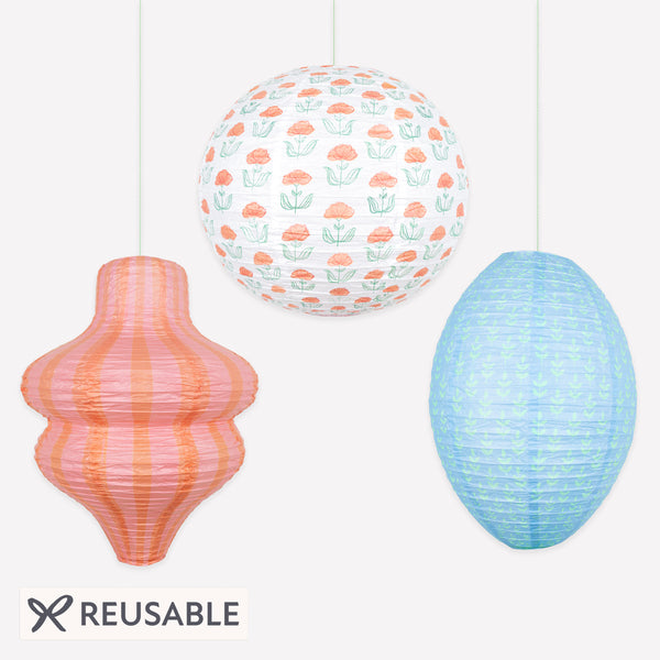 Our paper lanterns, a set of three with orange and blue floral and striped print designs, feature a round, oval and wavy shape. Image1