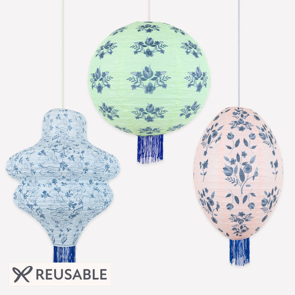 Our paper lanterns set, of three, come in mint, blue and pink, with round, wavy and oval shapes, with blue botanical illustrations and blue tassels. Image1