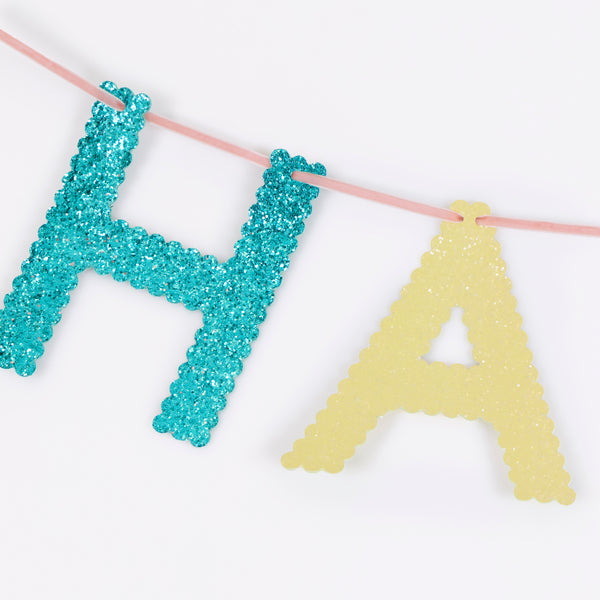 Our glitter garland features the words Happy Birthday in bright colours, with a pink velvet hanging ribbon, packaged in a fabric bag. Image3