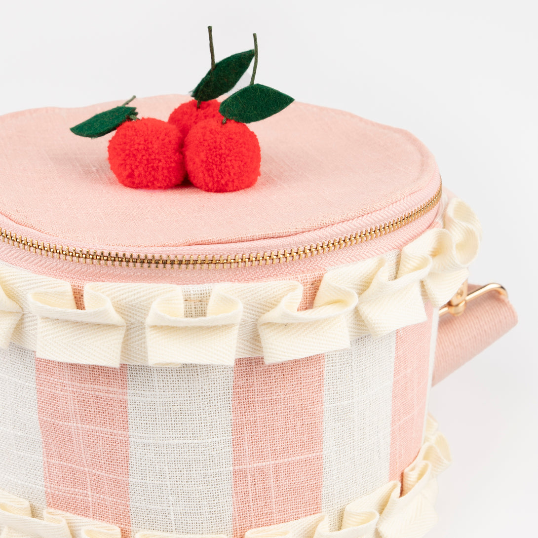 Our pink fabric bag, crafted to look like a cake, features fun pompom cherries, felt leaves, a ruffled ribbon and a long webbing handle.