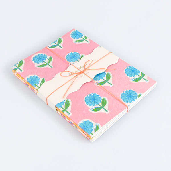Our lined notebooks come in a set of three, all with pretty floral covers, and tied together with a paper band and neon coral cord, a lovely gift. Image1