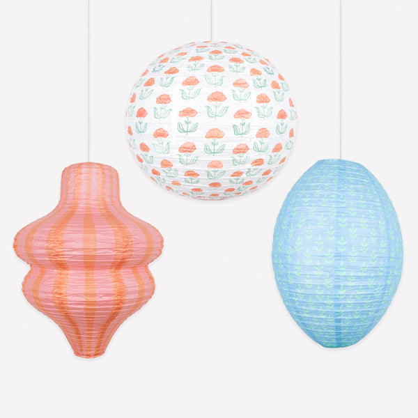 Our paper lanterns, a set of three with orange and blue floral and striped print designs, feature a round, oval and wavy shape. Image1
