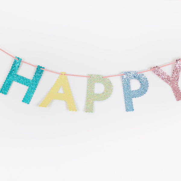 Our glitter garland features the words Happy Birthday in bright colours, with a pink velvet hanging ribbon, packaged in a fabric bag. Image2