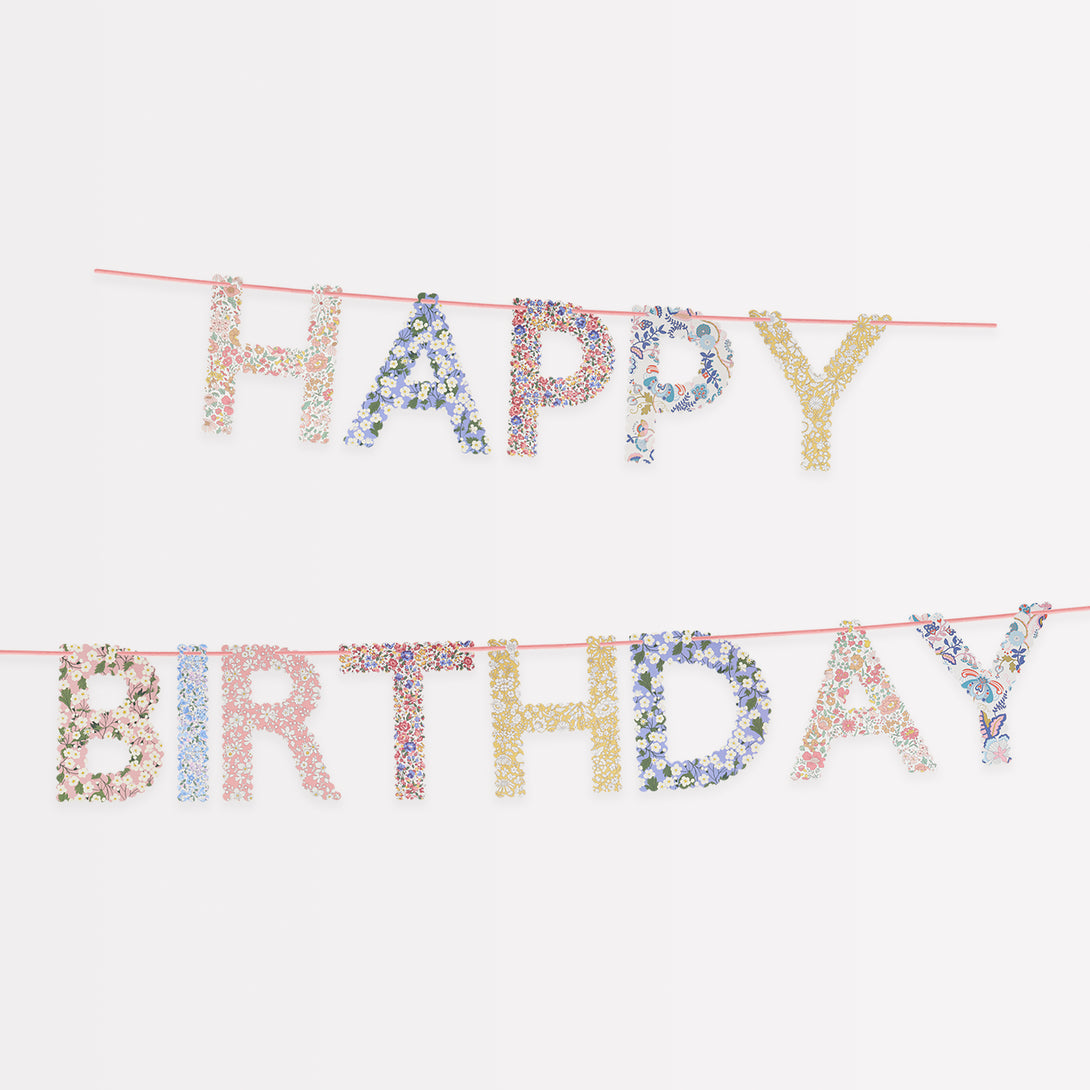 Our happy birthday garland features scalloped pennants with Liberty print designs, pre-strung on a pink velvet ribbon.