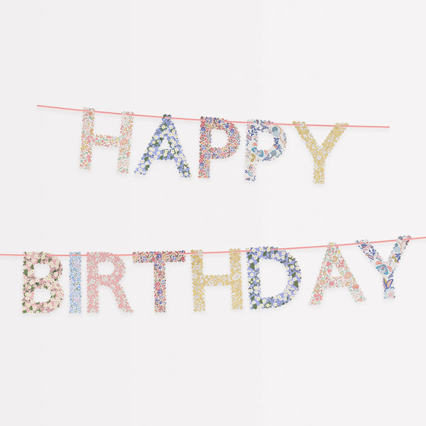 Our happy birthday garland features scalloped pennants with Liberty print designs, pre-strung on a pink velvet ribbon.