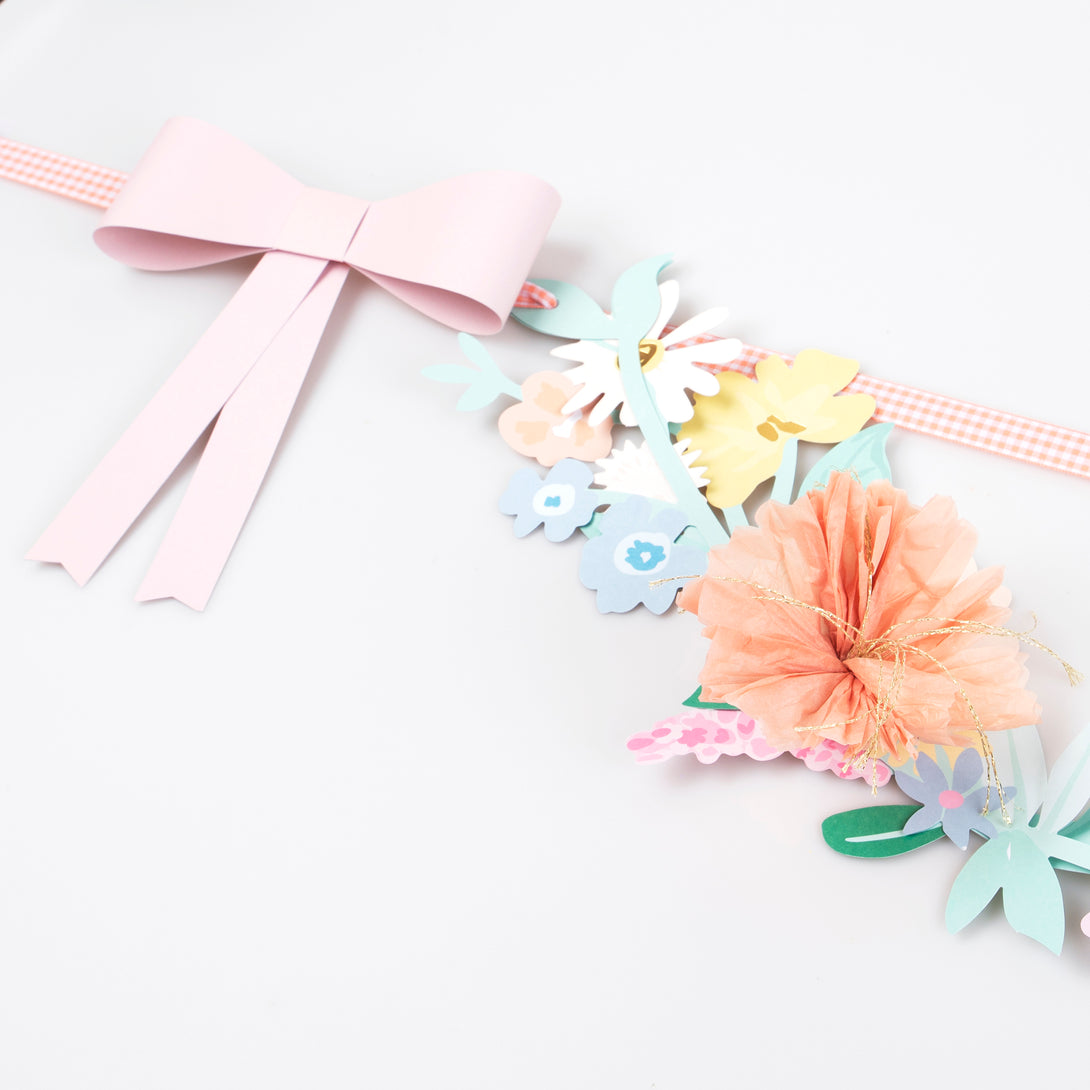 Our paper garland, featuring flowers and bows, is the perfect baby shower garland or Easter garland.