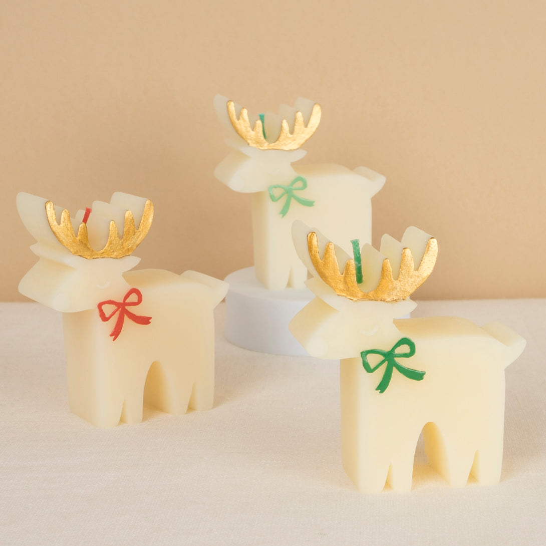 These Christmas table candles are reindeers with on-trend bows, gold details and fabulous coloured wicks, a great host gift.