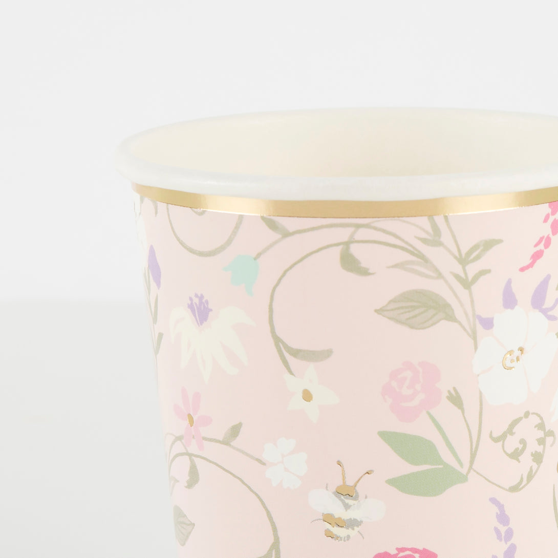 Beautiful pastel floral plates, cups, napkins, floral garland, and gold candles. 