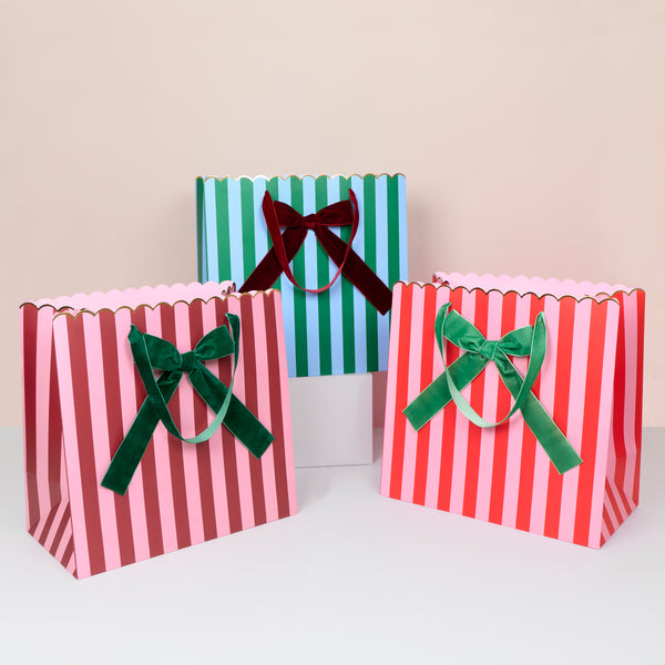 Our Christmas gift bags, made from premium paper, feature stripes of red, burgundy, green, pink and blue with velvet bows and velvet handles. Image1