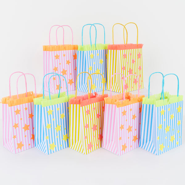 Our party paper bags feature stripes, stars and fringed details  in blue, pink and yellow, for a fun look, perfect for birthdays and fun celebrations. Image1
