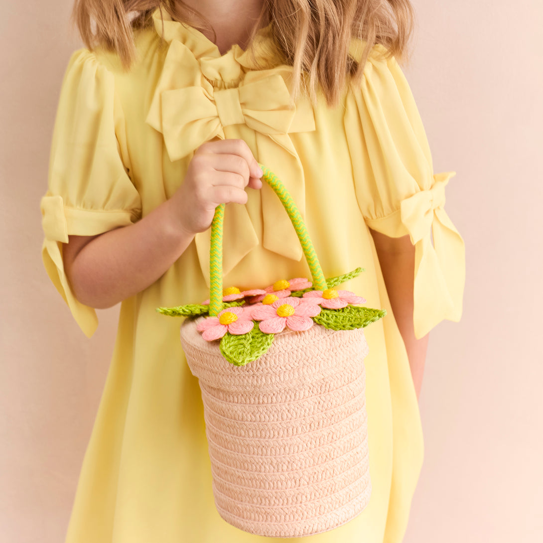 Our woven paper pink basket bag features paper flowers and leaves, a cord handle and a calico lining.