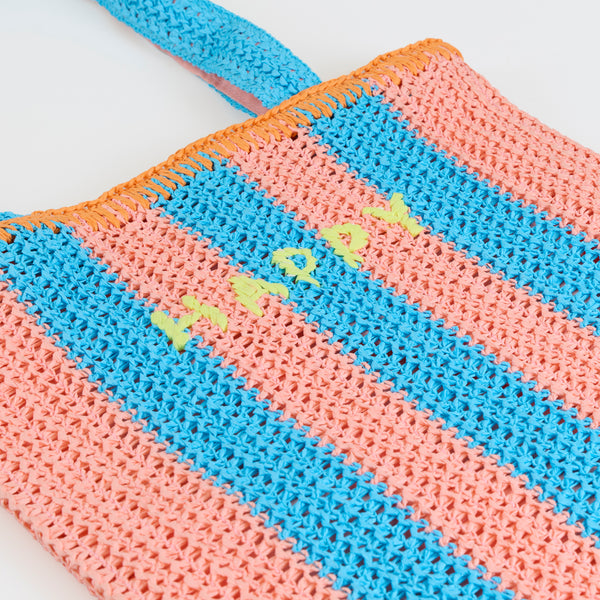 Our raffia bag, made from paper based raffia with pink and blue stripes, and an orange border, has the word Happy embroidered on the front. Image2