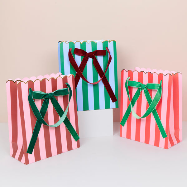 Our Christmas gift bags, made from premium paper, feature vibrant stripes in festive colours with velvet bows and velvet handles. Image1