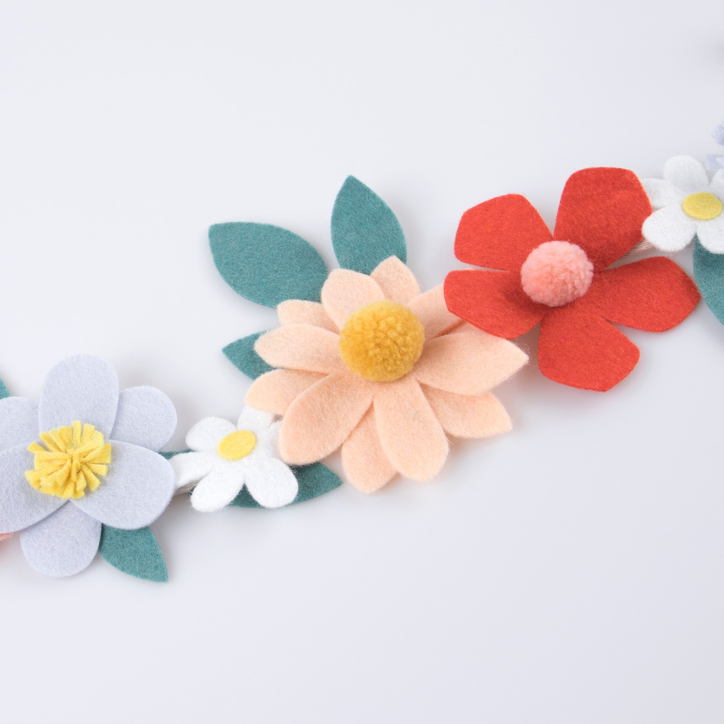Our special party garland is crafted from felt, with flowers with pompom centres.