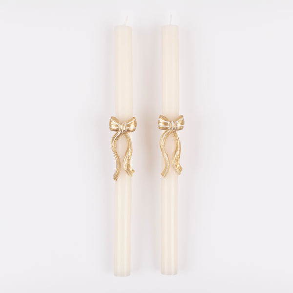 Our golden Christmas host gift set includes two table candles, with gold stripy bow details, and a pack of paper napkins with gold bow designs. 