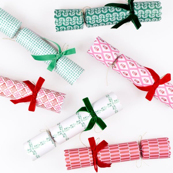Our luxury Christmas crackers feature Molly Mahon block print designs in seasonal colours and velvet bows, with a hat, joke and special gift inside. Image5