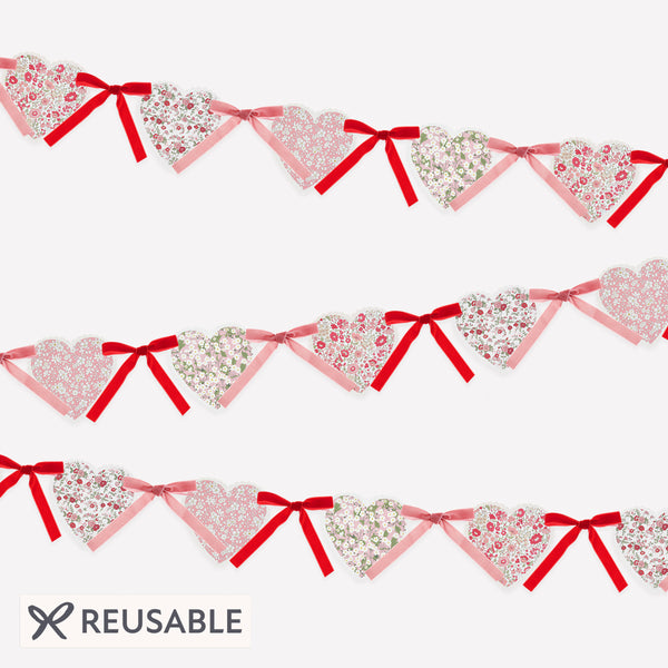 Our Valentine's Day garland feature paper hearts with floral Liberty print designs and pink and red luxe velvet bows. Image1