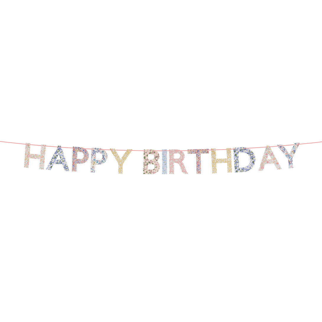 Our happy birthday garland features scalloped pennants with Liberty print designs, pre-strung on a pink velvet ribbon.