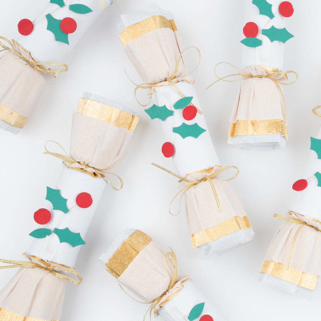 Our luxury holly Christmas crackers feature gold crepe paper and bows, and each contain a gold party hat, joke and a Christmas brooch.