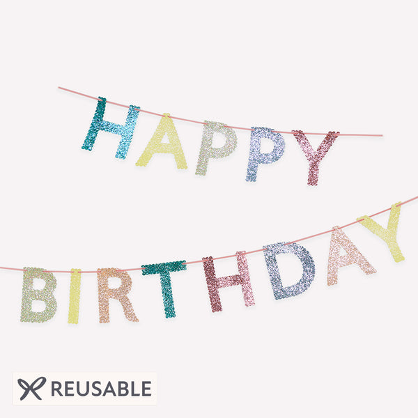 Our glitter garland features the words Happy Birthday in bright colours, with a pink velvet hanging ribbon, packaged in a fabric bag. Image1