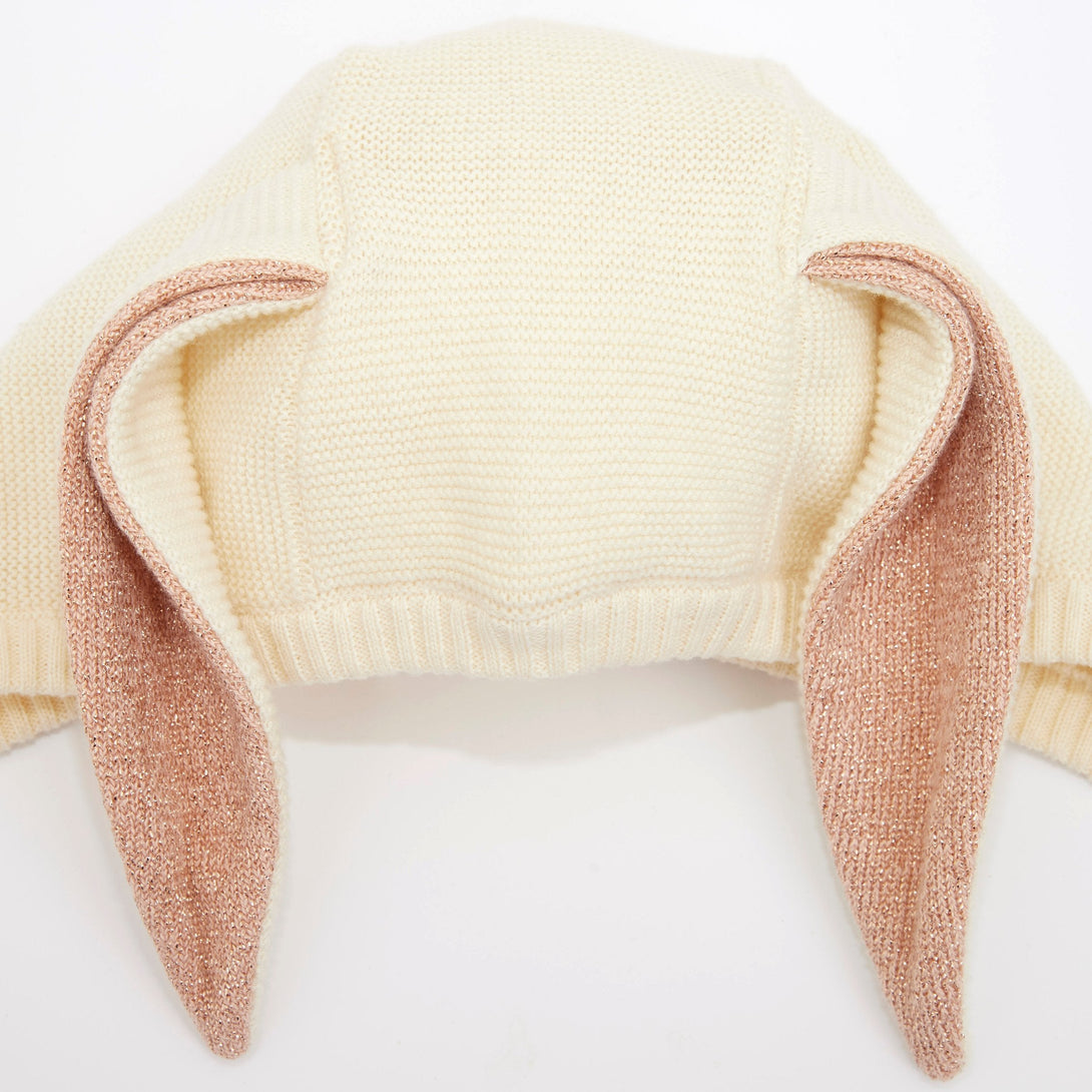 This organic cotton bunny bonnet has a shimmering peach inner on the ears, and an ivory coloured button fastening.