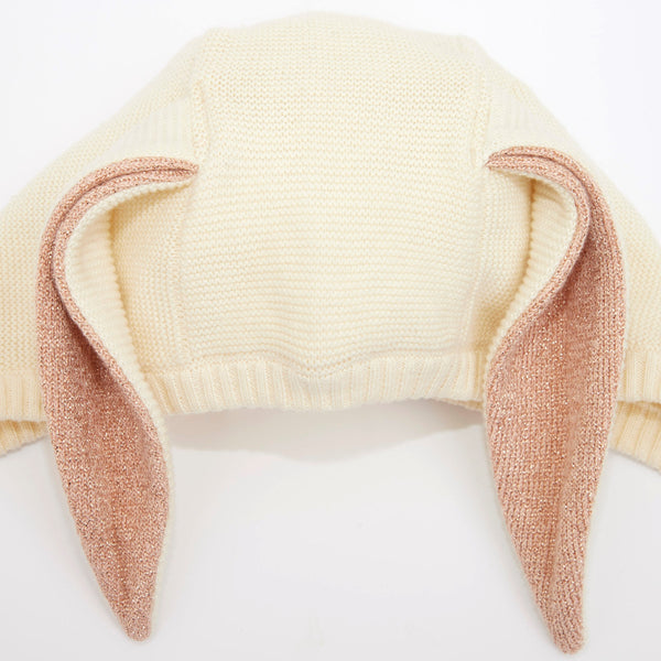 This organic cotton bunny bonnet has a shimmering peach inner on the ears, and an ivory coloured button fastening. Image4