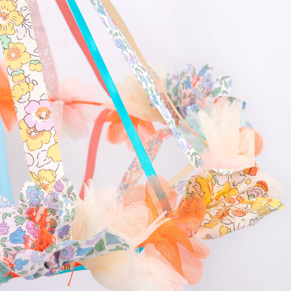 This hanging flower decoration is made from colourful fabric with streamers. Image3