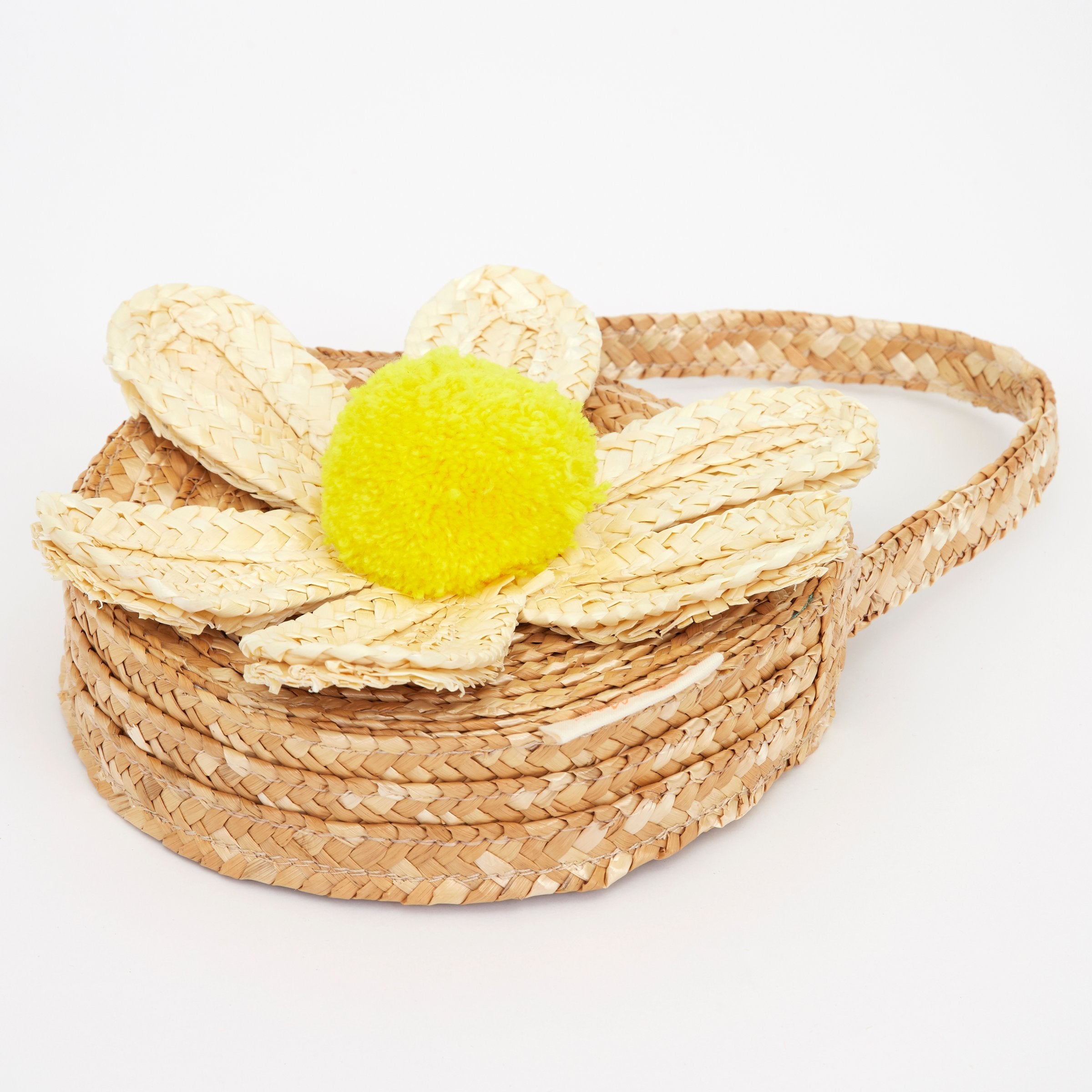 This sensational straw kids bag has a raffia daisy with a yellow pompom in the centre.