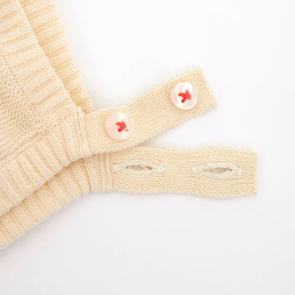 This organic cotton bunny bonnet has a shimmering peach inner on the ears, and an ivory coloured button fastening. Image3